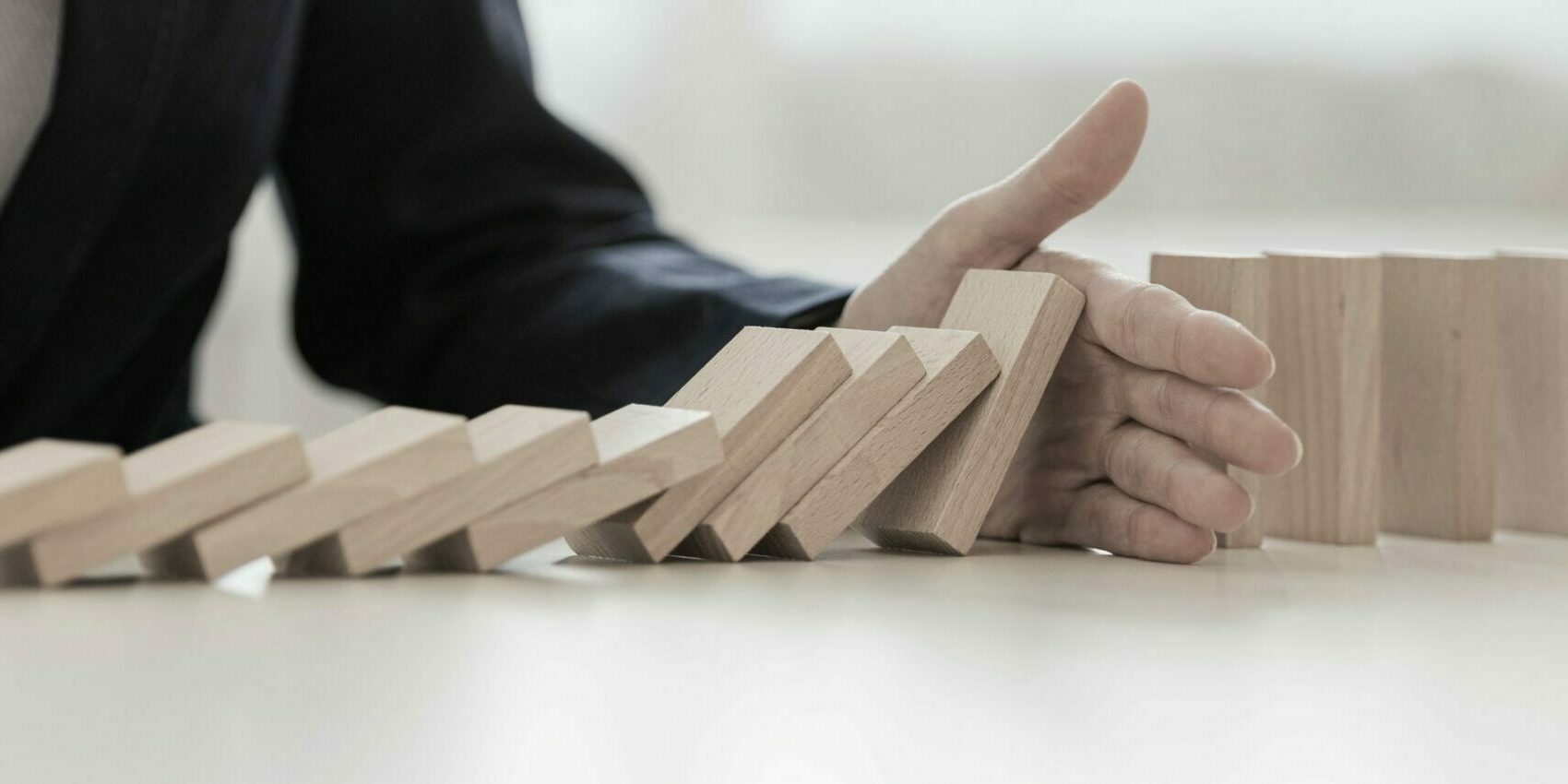 Wide,View,Image,Of,Hand,Of,Businesswoman,Interrupting,Collapsing,Dominos