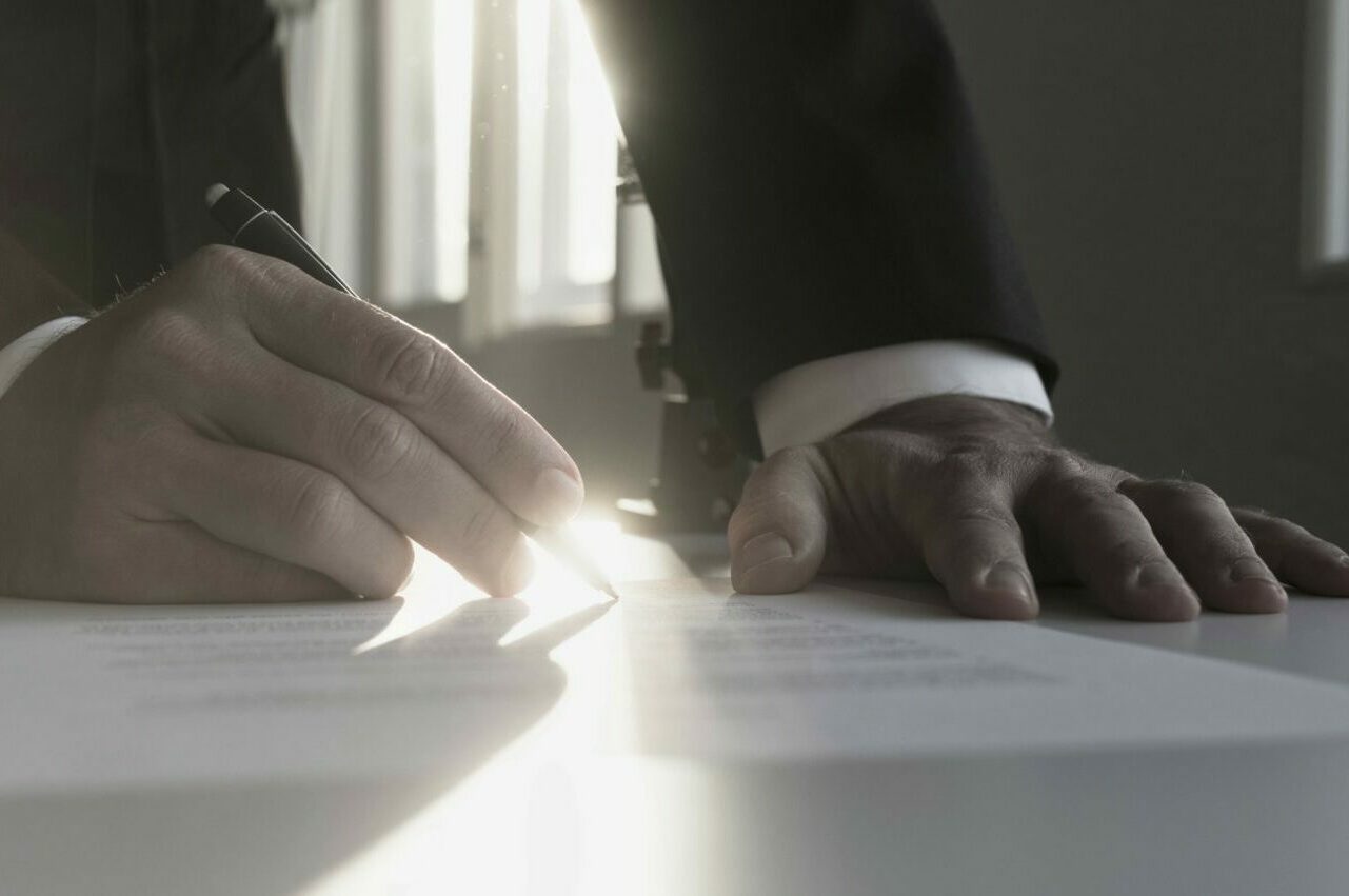 Panorama,View,Of,Businessman,In,A,Shadowy,Office,Signing,Contract Panorama,View,Of,Businessman,In,A,Shadowy,Office,Signing,Contract